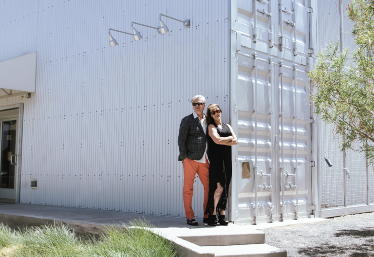 Tonya Turner Carroll and Michael Carroll stand in front of a large, white metal building